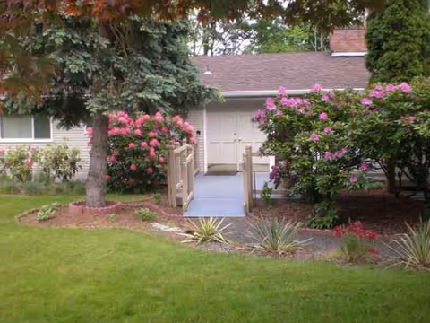 Exterior view of Brookwood House Inc showing walkway, entrance, and landscaped garden.