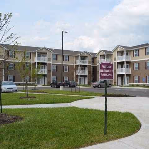 Multi-story senior living building with parking and a future resident parking sign.