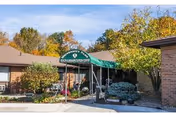 Exterior view of University Park Rehabilitation and Healthcare Center entrance with a green canopy and signage.