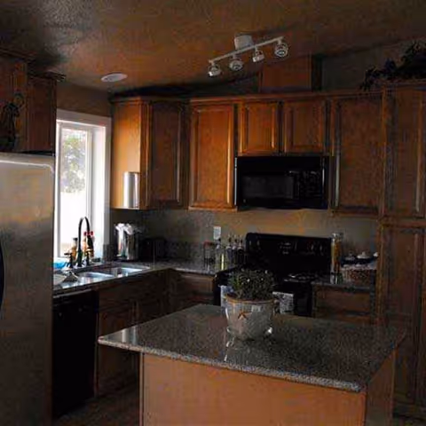 Senior living home kitchen with wood cabinets, stainless appliances, and a central island.
