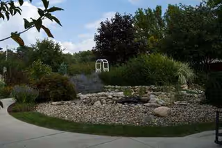 Manicured outdoor garden at Sanctuary at St Paul's with rocks, shrubs, and a curved path.