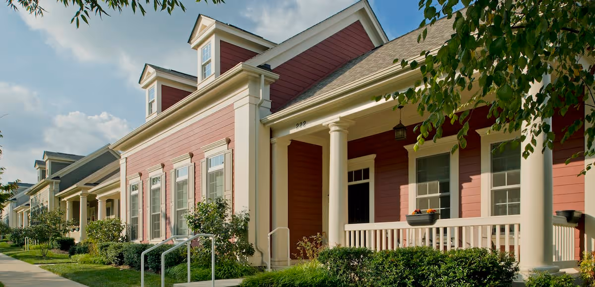 Red and cream single-story residences with porches, columns, and landscaped front yards.
