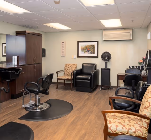 Interior salon room with styling chairs, a hooded dryer, cabinetry and additional seating.