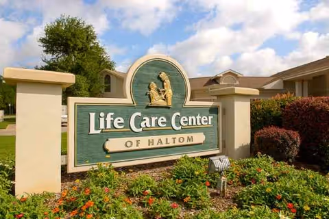 Outdoor view of Life Care Center of Haltom sign with landscaping and building behind.