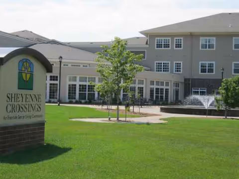 Exterior view of Eventide at Sheyenne Crossings showing entrance, fountain, and landscaped lawn.