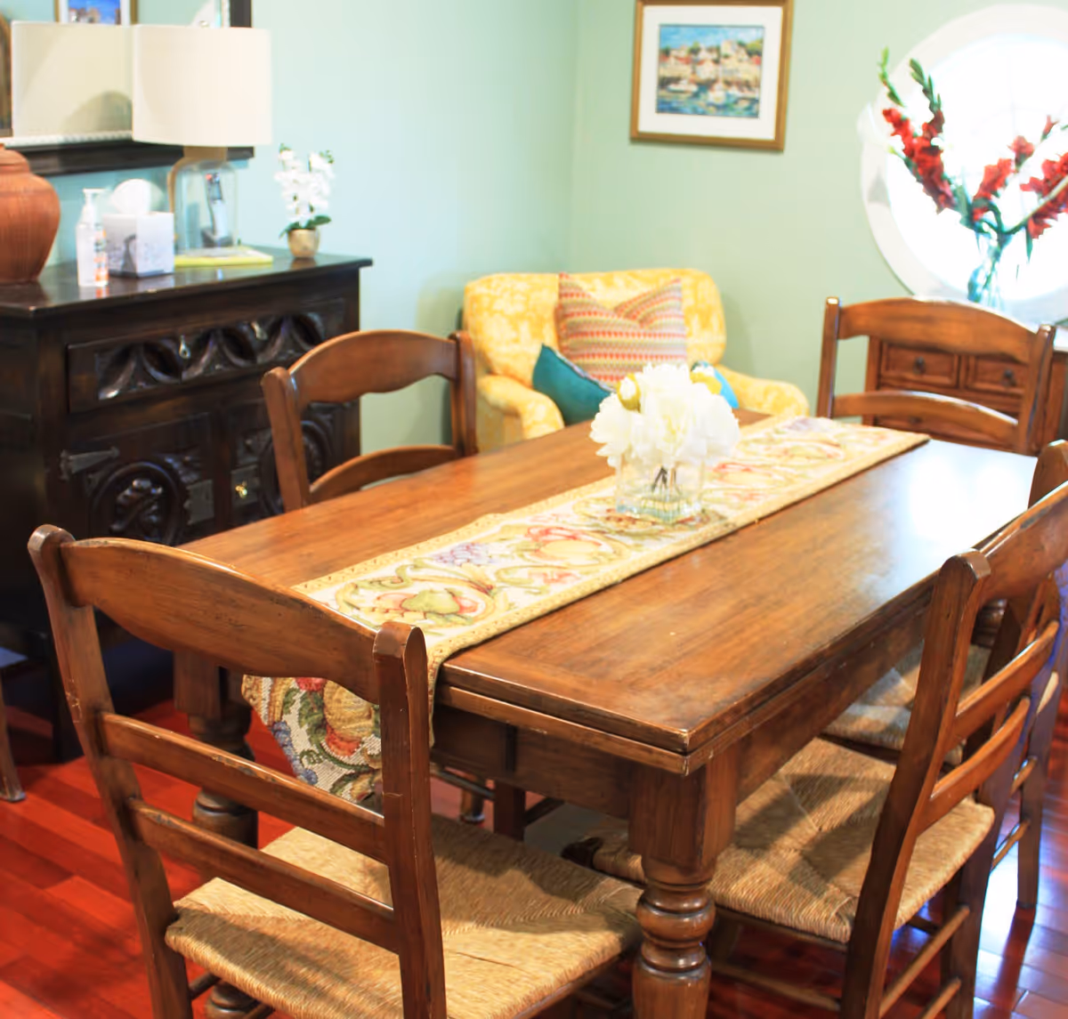 Wood dining table with chairs in a cozy dining room and flowers