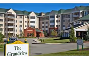 Front exterior of a multi-story retirement community building with a driveway, landscaping, and a sign reading 'The Grandview'.