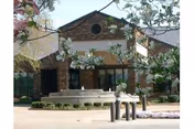 The Altenheim building front with brick façade, circular window, and surrounding trees.