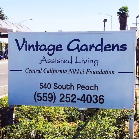 Large outdoor sign reads Vintage Gardens Assisted Living Community, Central California Nikkei Foundation, phone number.