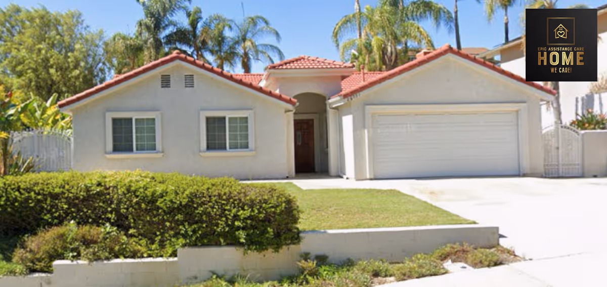 Front exterior of a single-story stucco house with a red tile roof, attached garage, driveway, and trimmed front lawn.