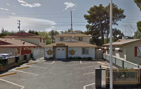 Front exterior of a small adult care home with a gated parking lot.