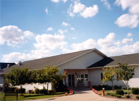 Single story senior living facility with front entrance and landscaped walkway.