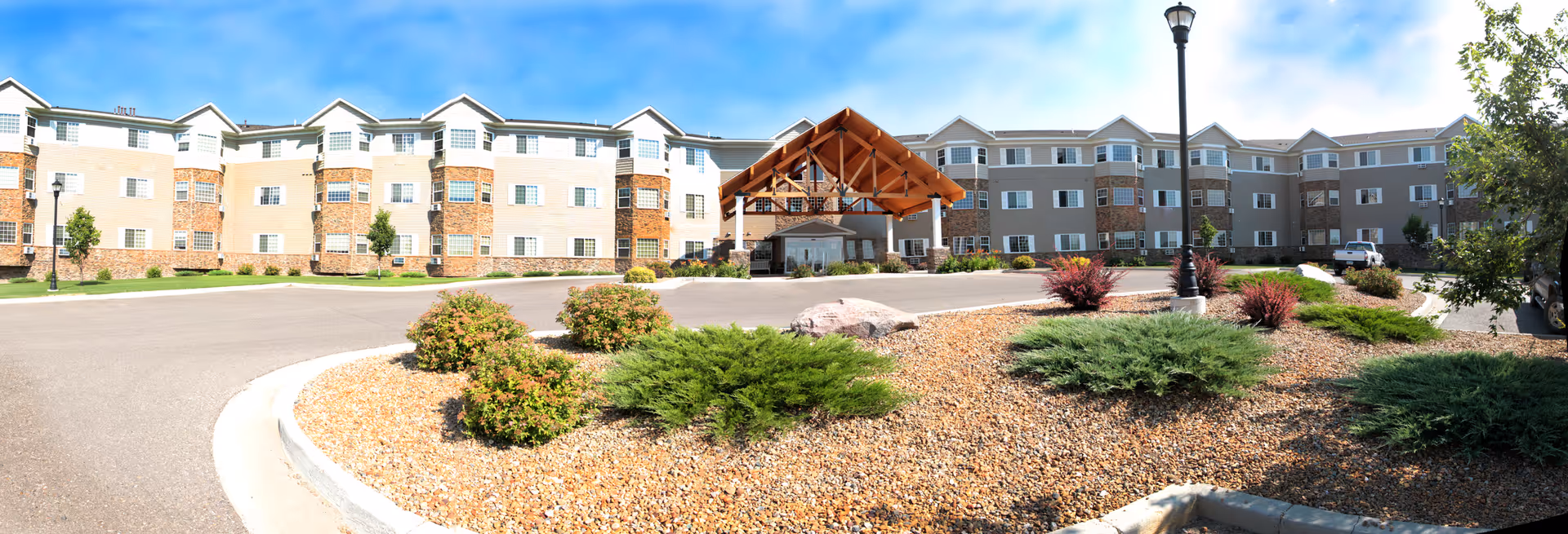 Wide view of Edgewood Bismarck Village exterior with entrance canopy and landscaped lot.