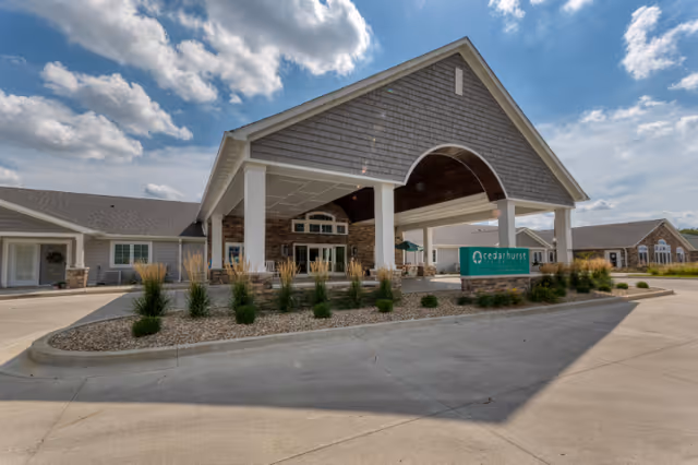 Front entrance of Cedarhurst Senior Living with porte-cochere and landscaped driveway.