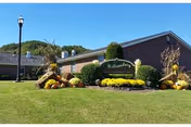 Front exterior of Williamsburg Nursing Home with a manicured lawn and landscaping.
