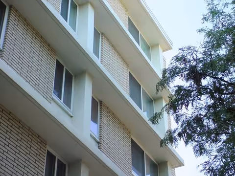 Exterior view of a multi-story brick senior living residence with windows and trees