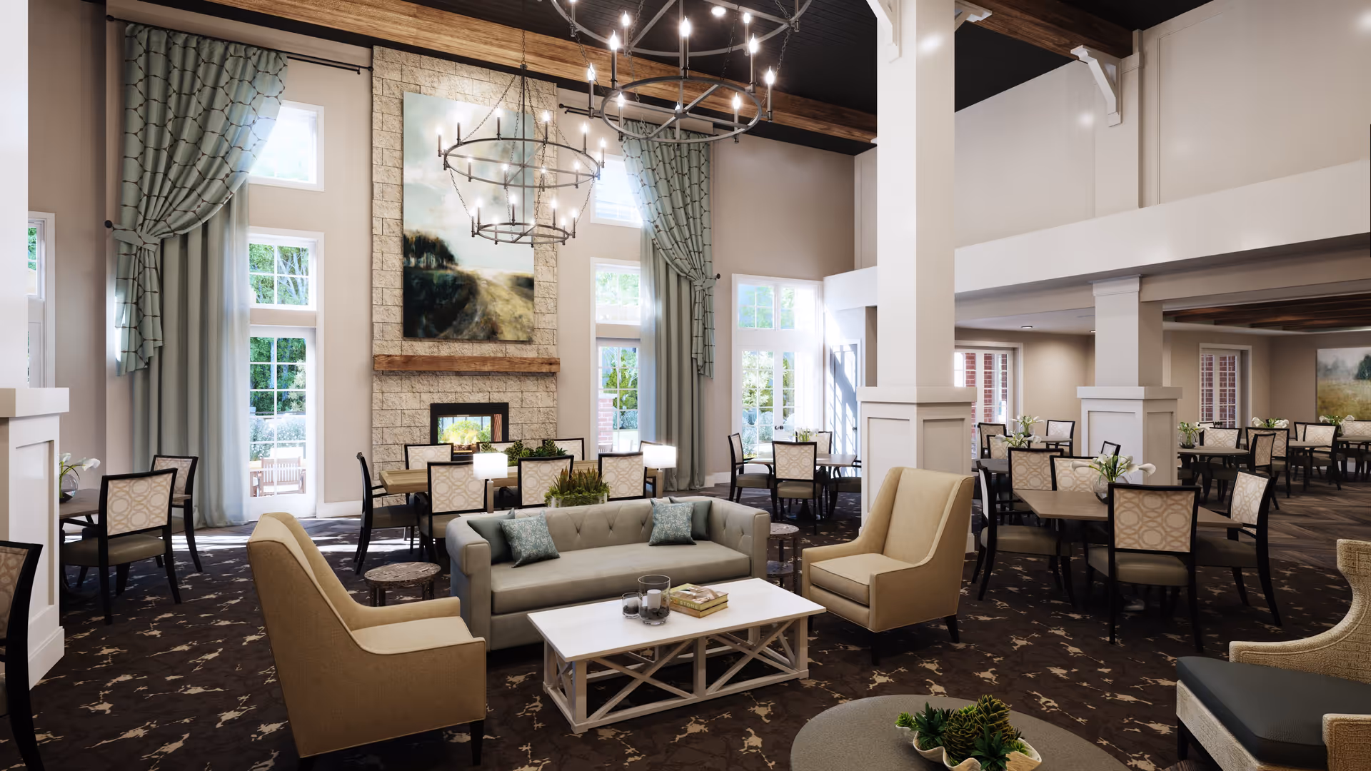 A spacious and elegant common area in a senior living facility featuring a seating area with a gray sofa, two beige armchairs, and a white coffee table. Behind the seating area are multiple dining tables with chairs, large windows with light blue curtains, and a stone fireplace with a large painting above it. The room has high ceilings with wooden beams and two large circular chandeliers.