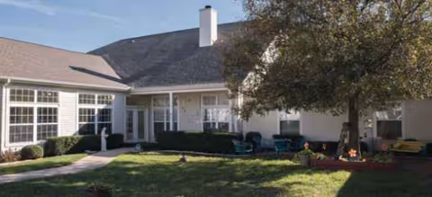 Front view of a Brookdale Midwestern senior living facility with lawn and outdoor seating.