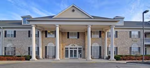 Front view of a Brookdale Muirfield senior living facility with tall columns and entrance.