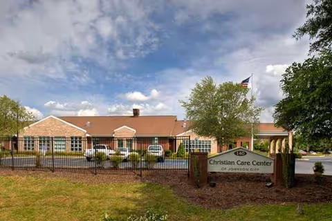 Brick senior care facility with a fenced entrance and Christian Care Center sign.