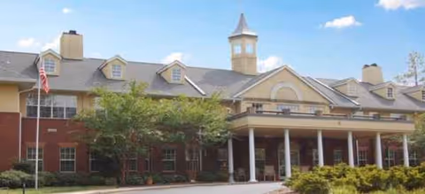 Exterior view of Brookdale MacArthur Park: brick senior living building with covered entrance and flagpole.