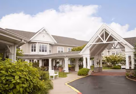 Exterior view of Sunrise of Holbrook senior living facility with a covered entrance