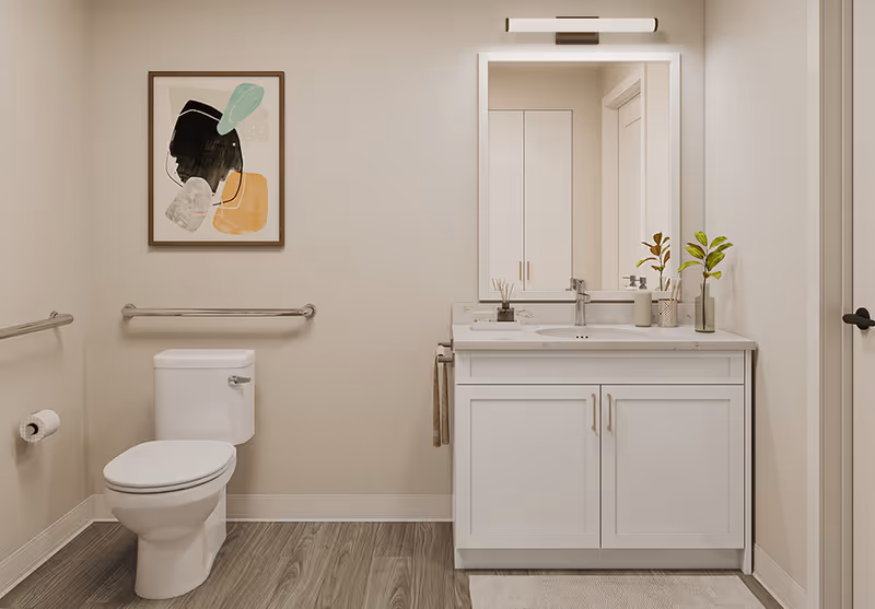 Accessible bathroom with a toilet, wall grab bars, a white vanity with sink and mirror, and framed artwork on the wall.