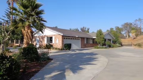 Front exterior view of Citiview Residential Care building with curved driveway and palm trees.