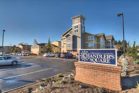 Exterior view of Chandlers Square Retirement Community with sign and clock tower.