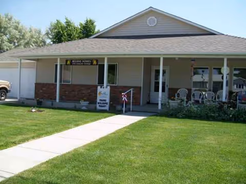 Exterior view of Willow Creek of Cody showing a covered porch with chairs.