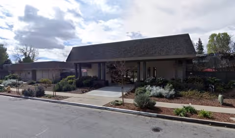 Crestwood Manor exterior entrance with a covered drive and landscaped front.