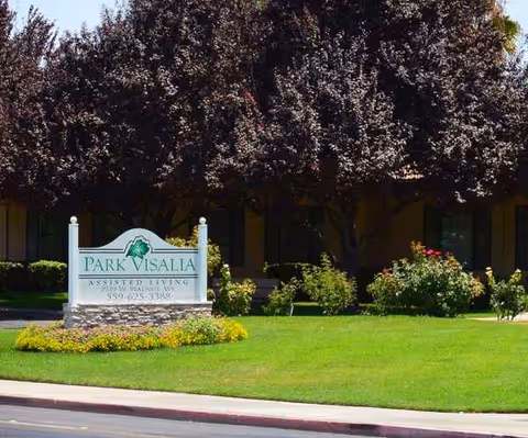Park Visalia Assisted Living sign in front of a manicured lawn and trees.