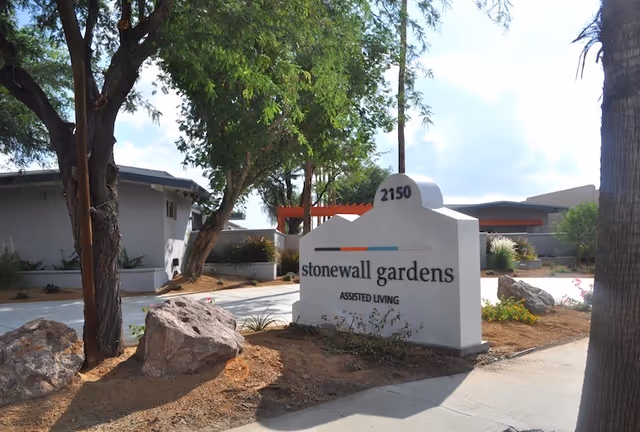 Stonewall Gardens Assisted Living entrance sign with trees and landscaping