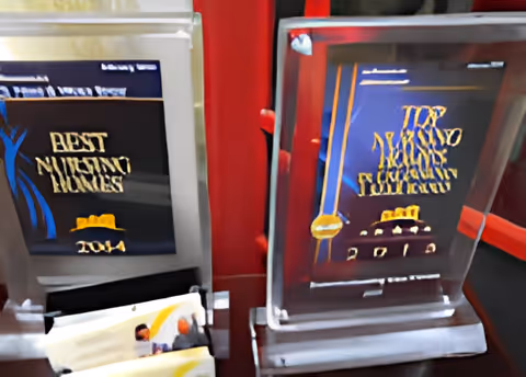 Two acrylic award plaques on a shelf, each displaying nursing home awards and the year 2014.