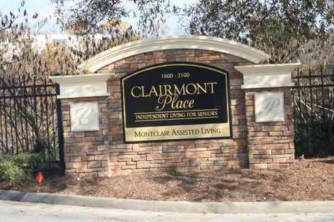 Brick entrance sign with curved top displaying 'CLAIRMONT Place' branding for Montclair Assisted Living.