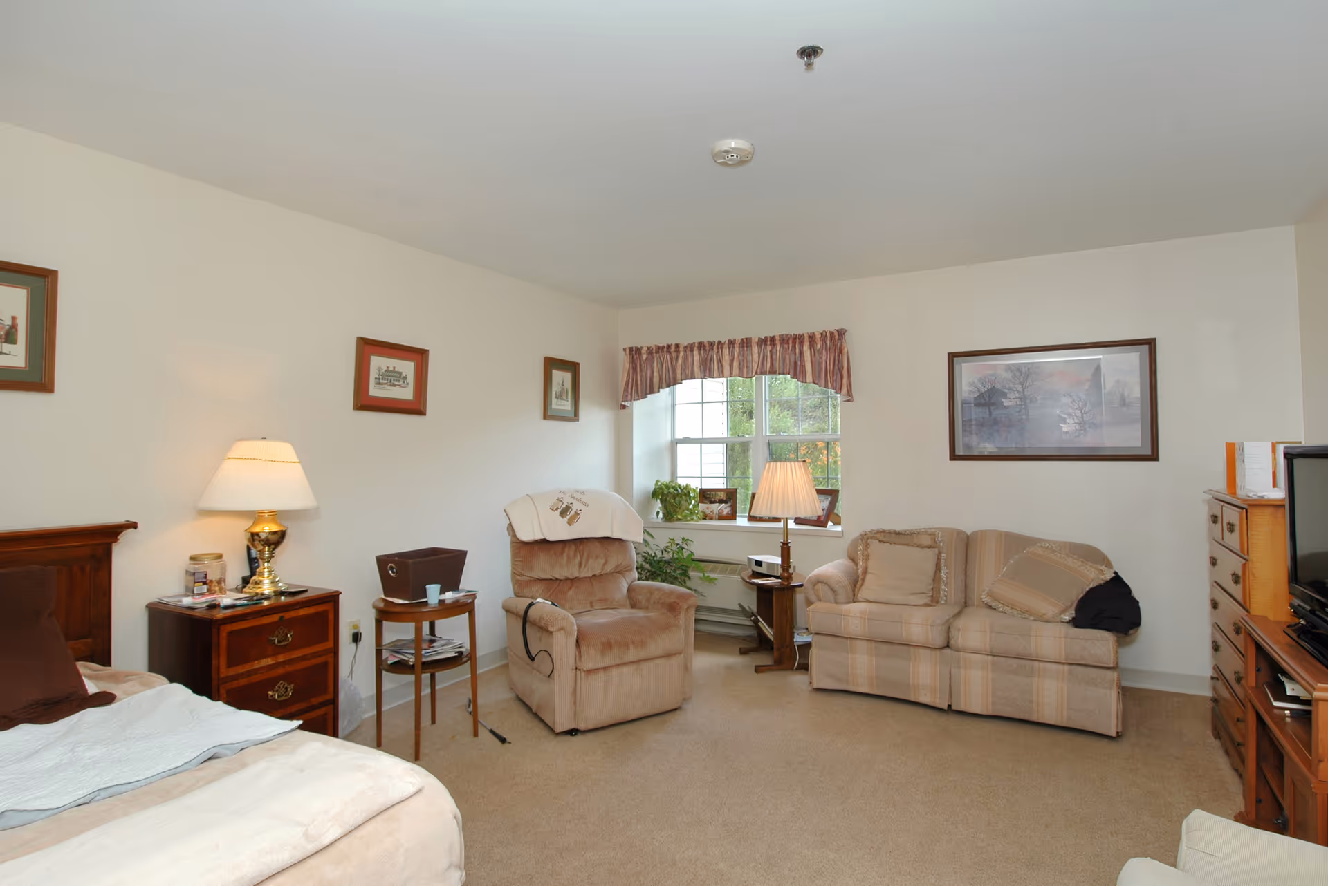 Cozy living area with seating and decorative items in a senior living facility.