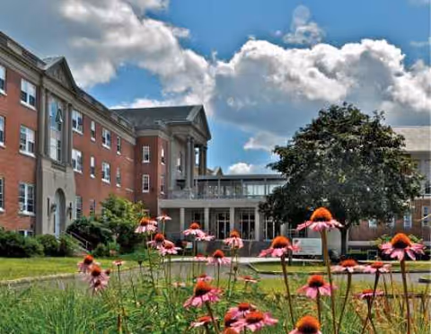 Exterior view of Mount St. Rita Health Centre with brick facade and flower beds.