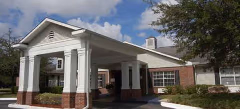 White Brookdale Southpoint exterior featuring a covered entrance and brick columns.