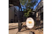 Gate and circular sign for Sundance Skilled Nursing and Rehabilitation at the entrance to a courtyard in front of a multi-story building.