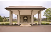 Front view of Stella Manor facility with a covered entrance and landscaped surroundings.