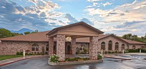 Exterior view of a brick Bishop Care Center building with a covered drop-off area.