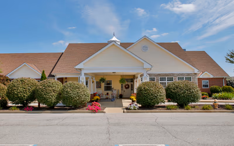 Front view of Bickford of Lafayette entrance with manicured shrubs and walkway.