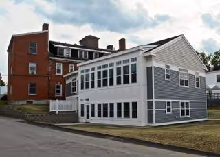 Exterior of Morrison Skilled Nursing and Assisted Living showing brick building and blue-gray annex.