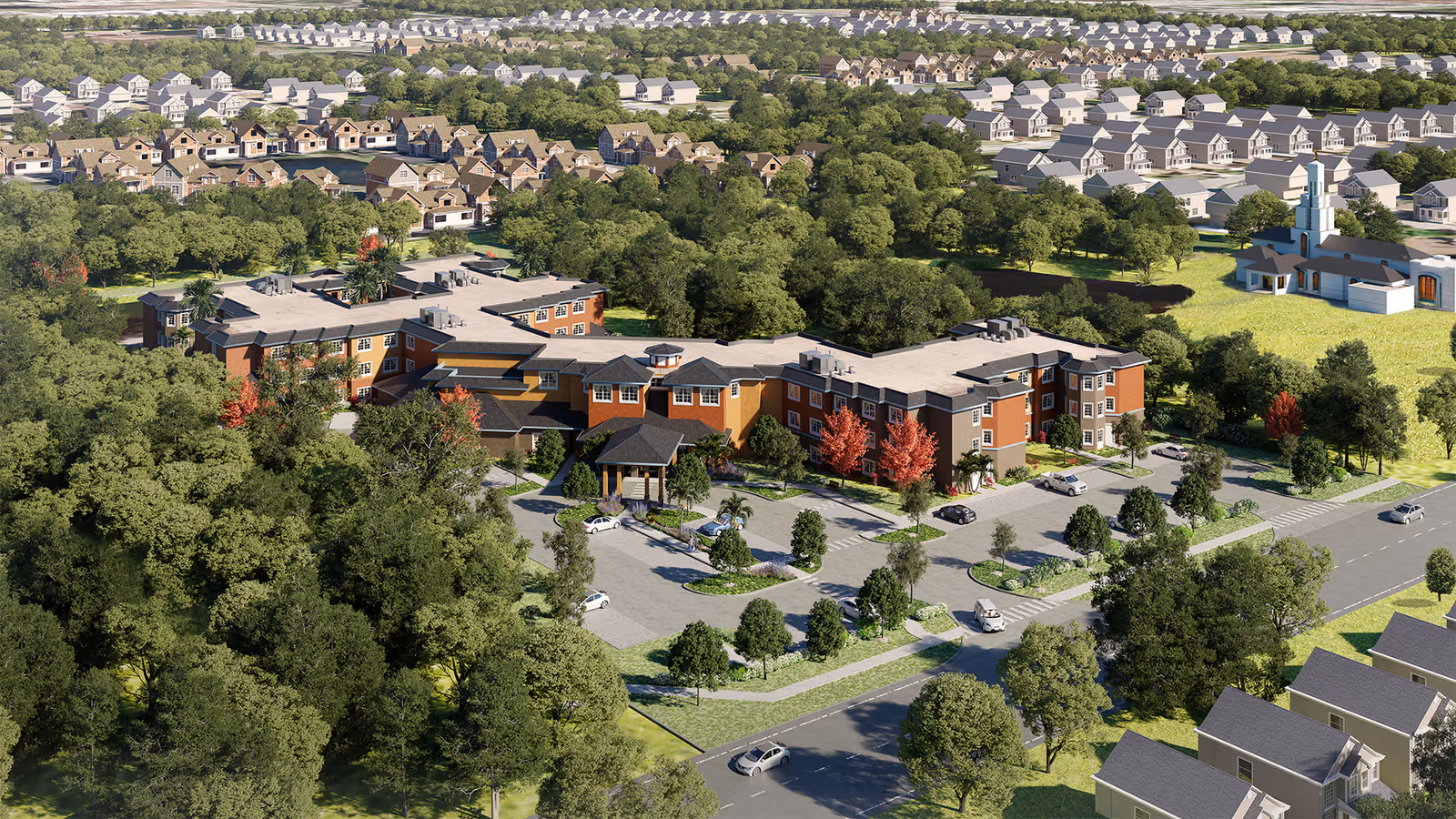 Aerial view of SaraBella Senior Living facility surrounded by trees and greenery, with a parking lot in front and residential houses in the background under a clear sky.