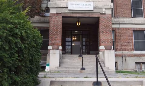 Front entrance of Christopher House senior living facility with brick facade and steps.