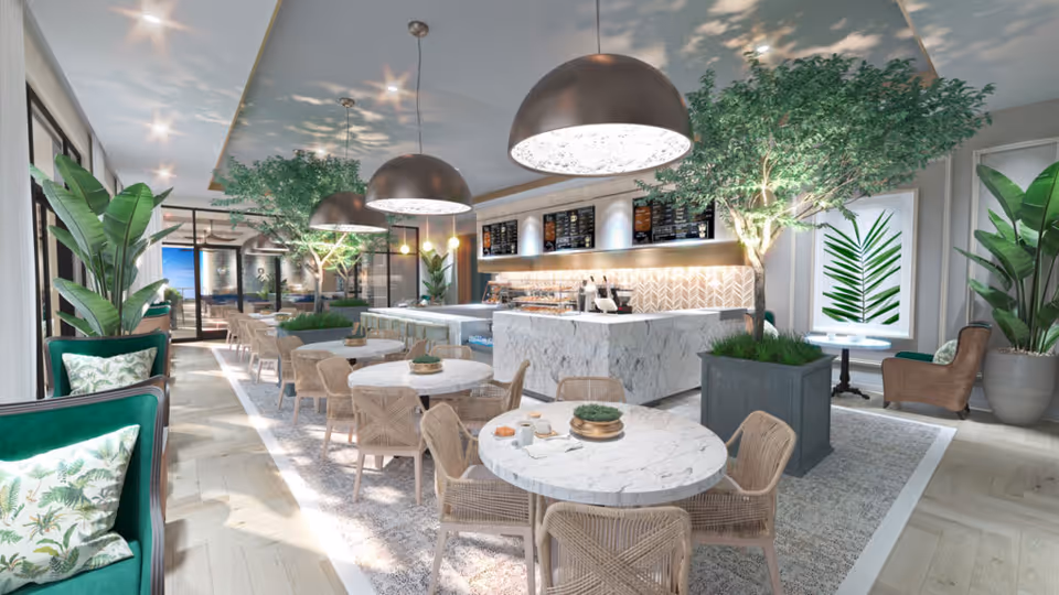 A bright and modern dining area in a senior living facility featuring round marble tables with wicker chairs, large pendant lights hanging from the ceiling, and lush green plants including potted trees and leafy plants. The space has large windows allowing natural light to fill the room, a marble counter with a menu board above it, and comfortable seating with green cushions and botanical-themed pillows.