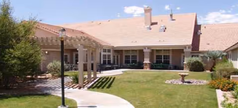 Exterior view of Brookdale East Tucson senior living facility featuring a courtyard, lawn, and walkway.