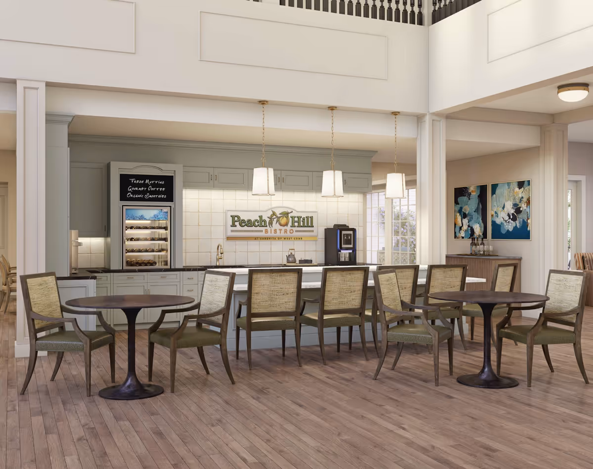 Bright dining bistro with round tables and chairs facing a serving counter and a sign reading "Peach Hill Bistro".