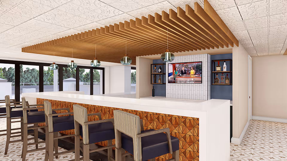 Modern indoor bar area with a white countertop, wooden slatted ceiling feature, pendant lights, and barstools facing a wall-mounted TV.