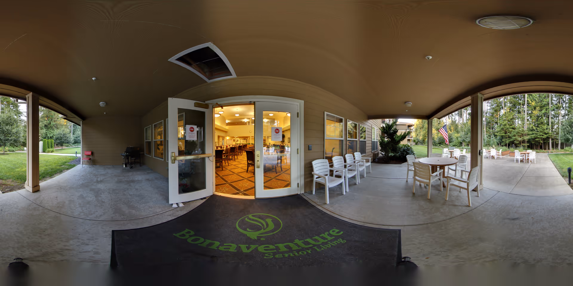 Covered front entrance patio of Park Vista by Bonaventure with a branded welcome mat, outdoor seating and double doors leading into a dining room.